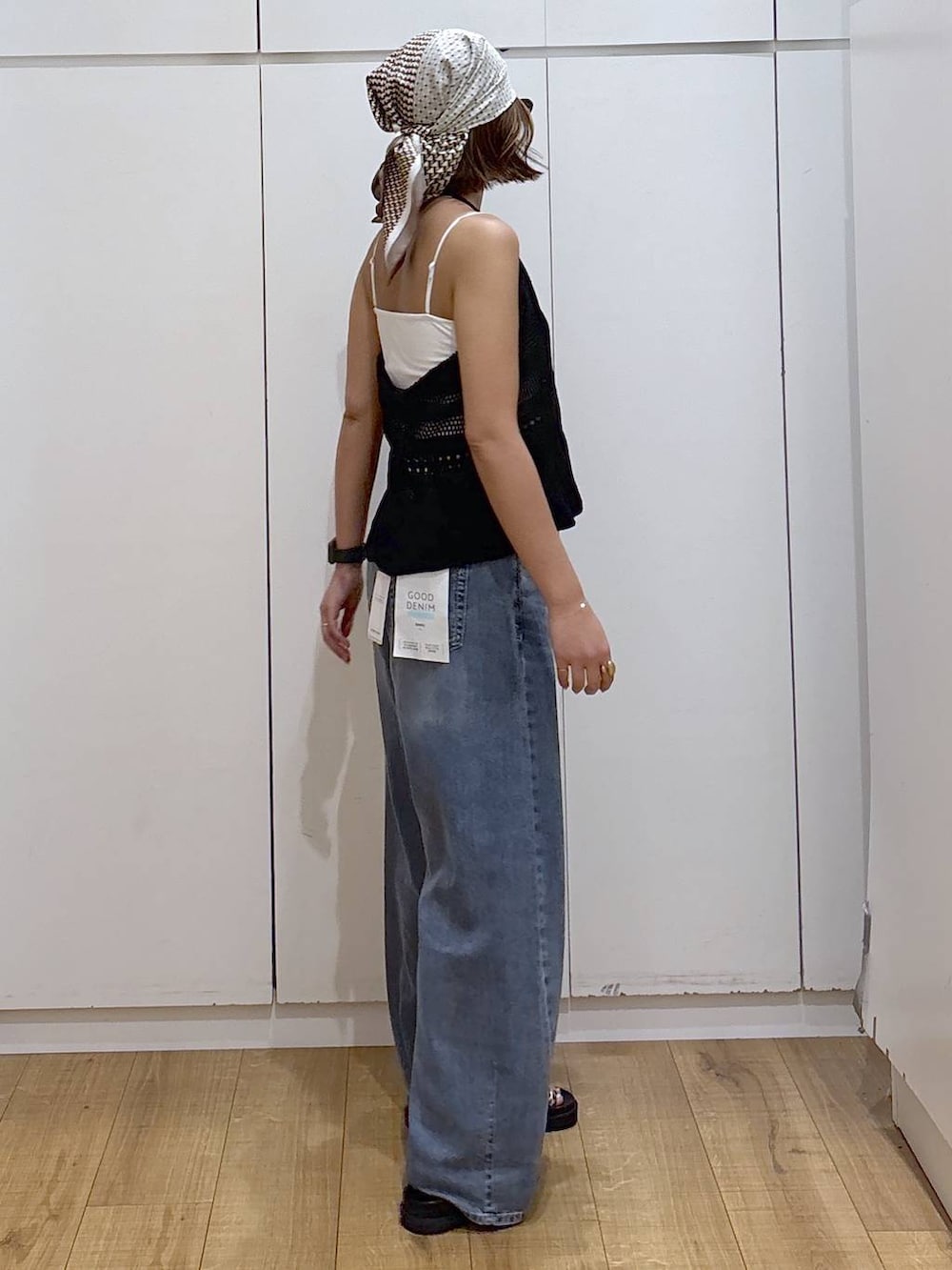 ホワイト系のキャミソール、ブルー系のデニムパンツ、ブラック系のサンダルを着用したレディースの春コーディネートの5枚目の写真