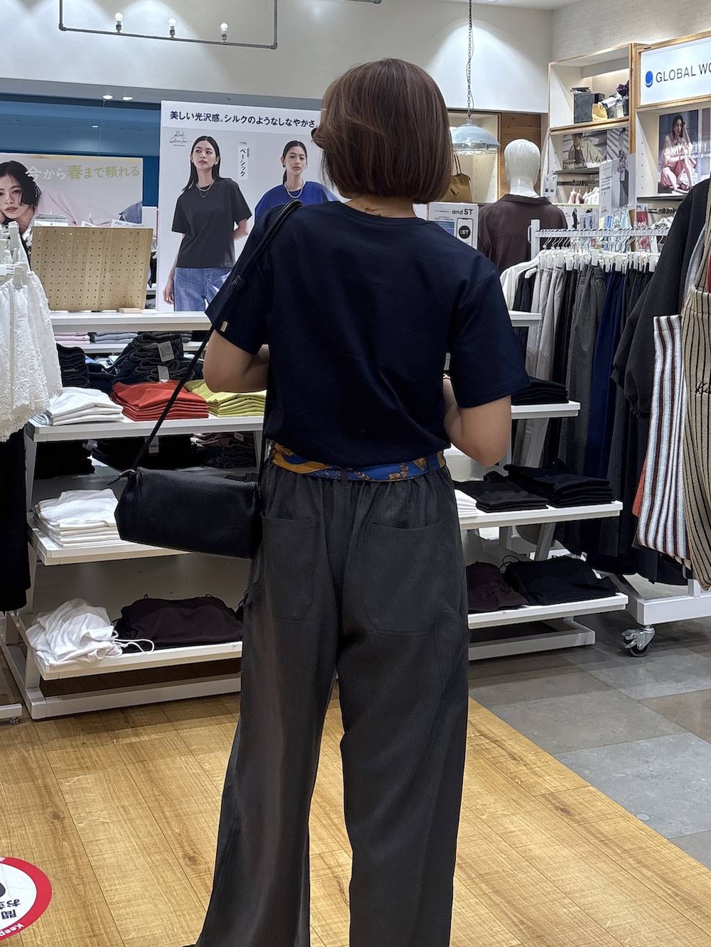 ブラック系のショルダーバッグ、グレー系のその他パンツ、ブルー系のTシャツ/カットソーを着用したレディースの春コーディネートの6枚目の写真