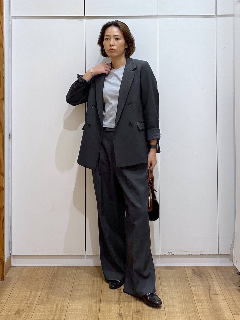 ブラック系のローファー、グレー系のその他パンツ、グレー系のテーラードジャケットを着用したレディースの秋コーディネートの3枚目の写真