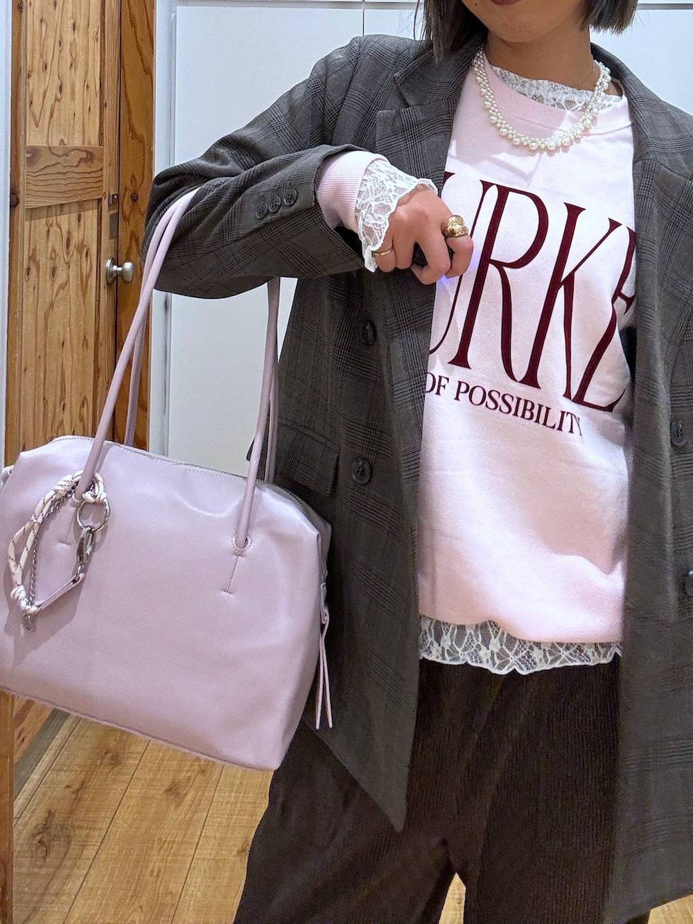 パープル系のボストンバッグ、ホワイト系のTシャツ/カットソー、ブラウン系のテーラードジャケットを着用したレディースの秋コーディネートの8枚目の写真