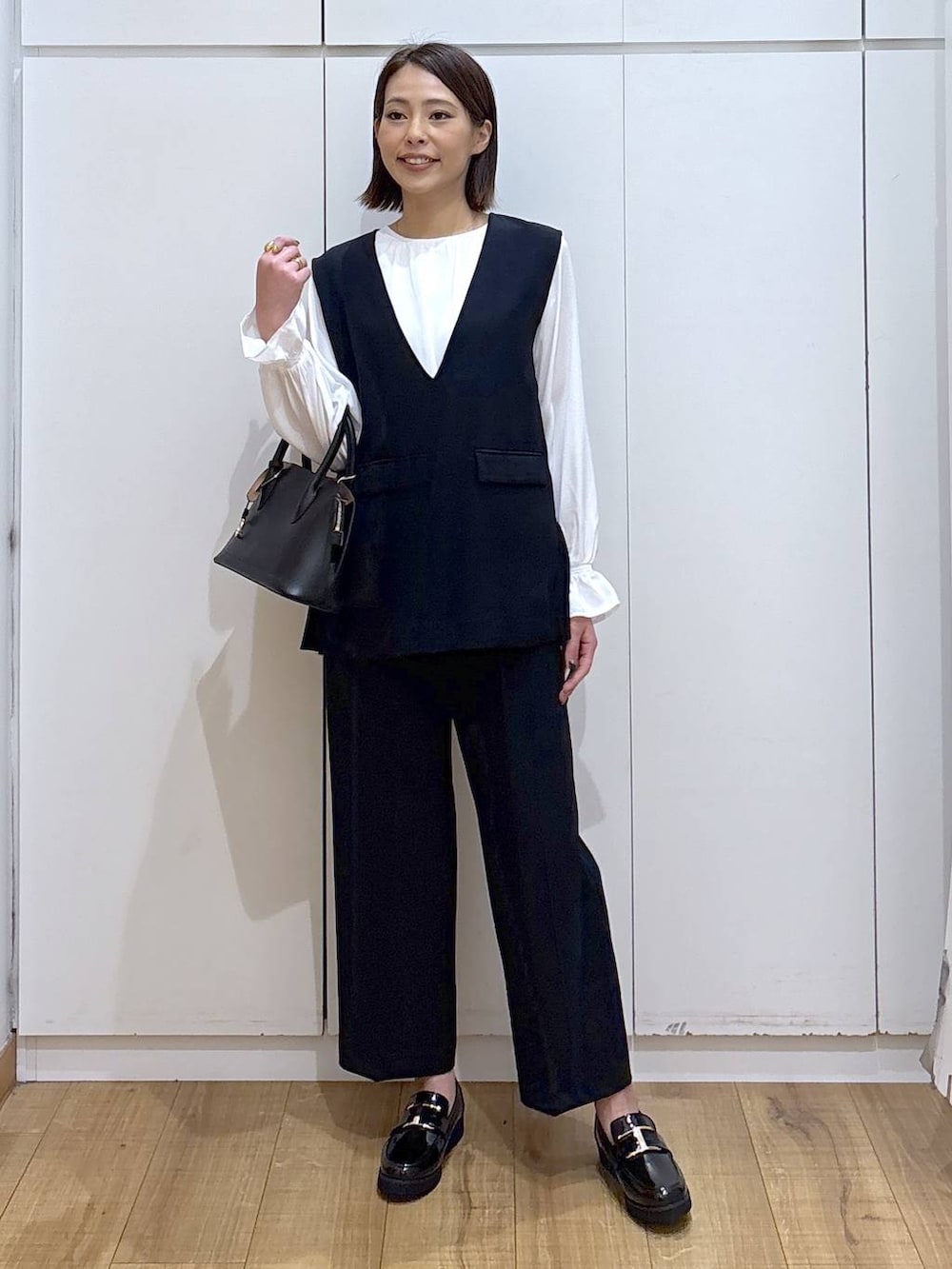 ブラック系のローファー、ブラック系のショルダーバッグ、ブルー系のセットアップを着用したレディースの冬コーディネートの2枚目の写真