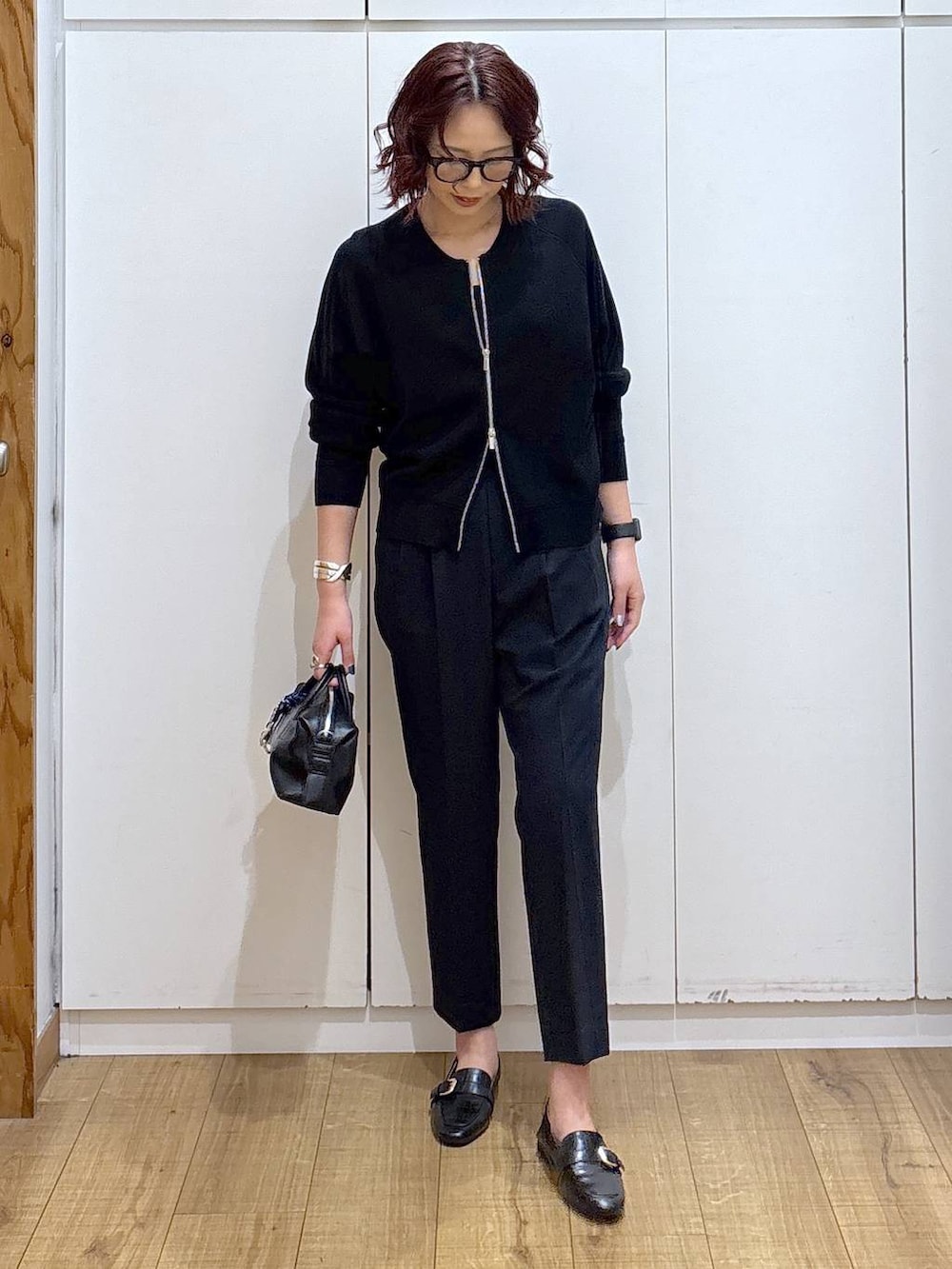 ブラック系のローファー、ブルー系のスラックス、ブラック系のカーディガン/ボレロを着用したレディースの春コーディネートの4枚目の写真