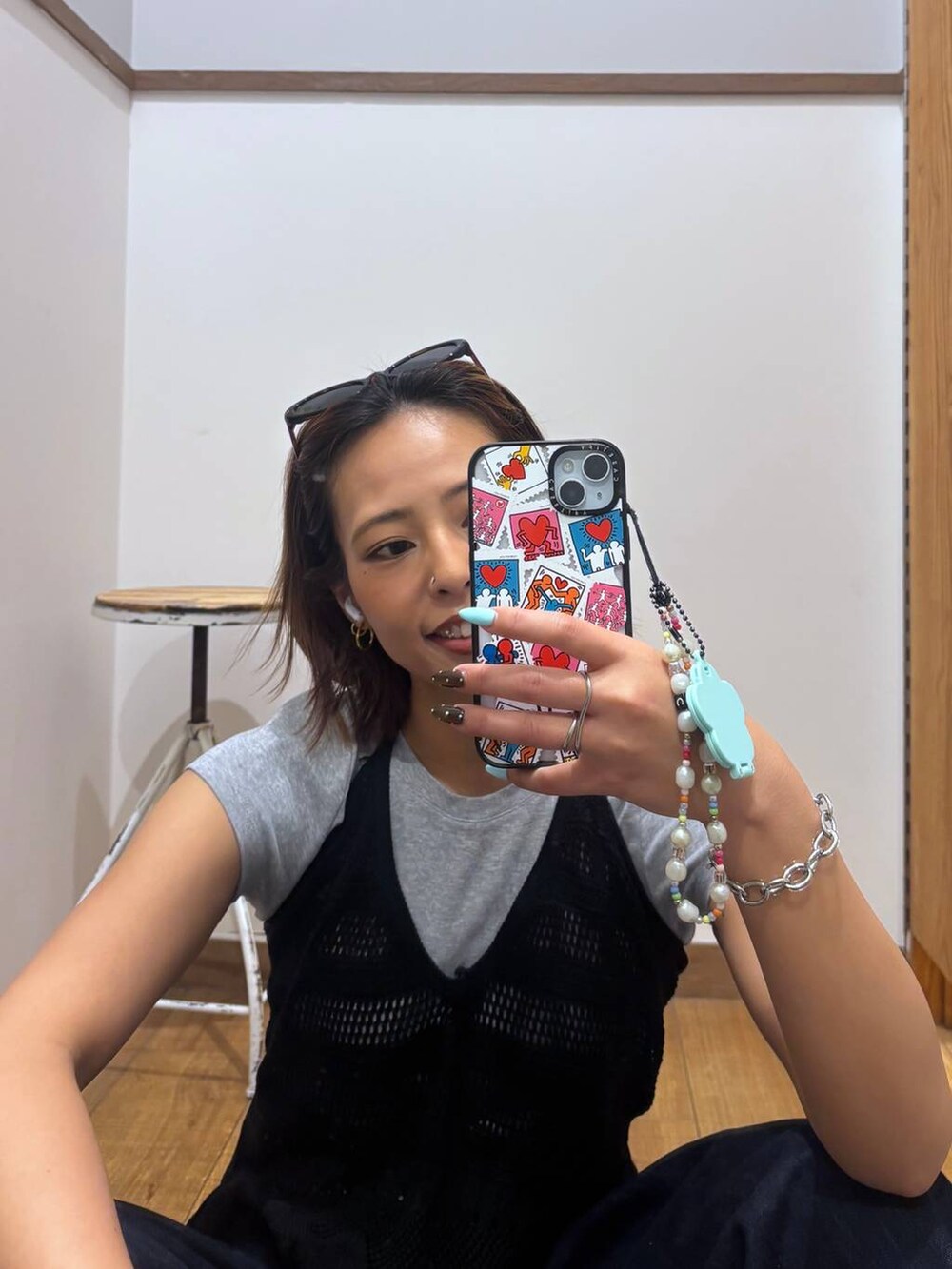 ブルー系のデニムパンツ、ブラック系のサンダル、ブラック系のベストを着用したレディースの春コーディネートの5枚目の写真