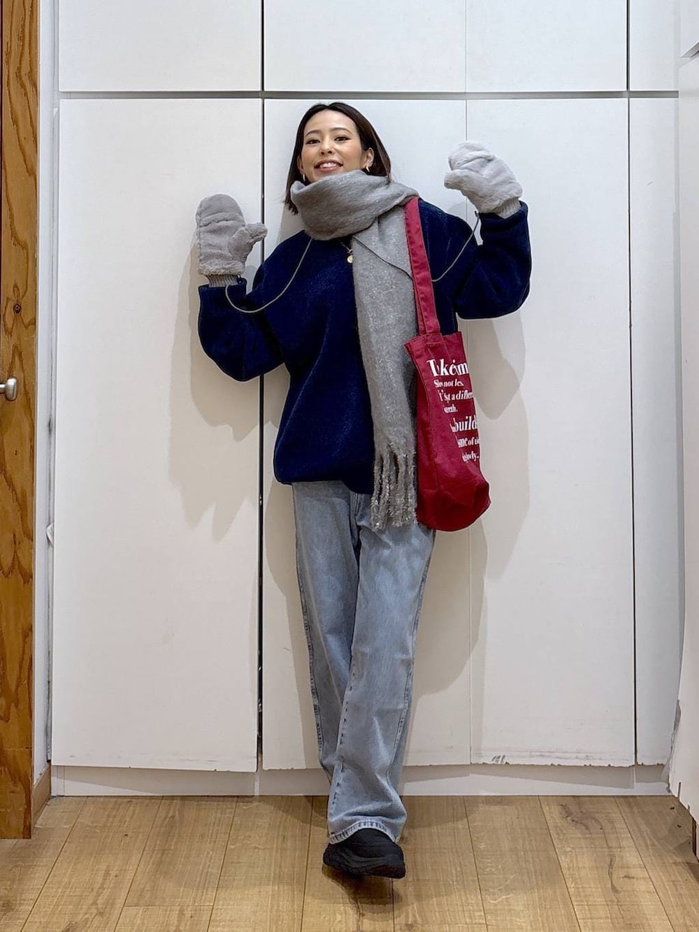 ブルー系のデニムパンツ、ホワイト系のTシャツ/カットソー、レッド系のトートバッグを着用したレディースの冬コーディネートの5枚目の写真