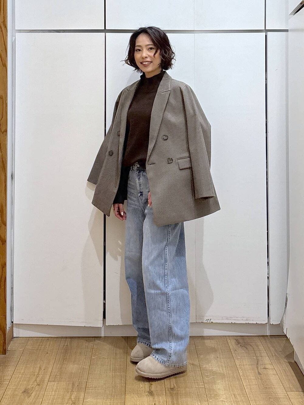 ブルー系のデニムパンツ、ブラウン系のニット/セーター、ブラウン系のテーラードジャケットを着用したレディースの冬コーディネートの6枚目の写真