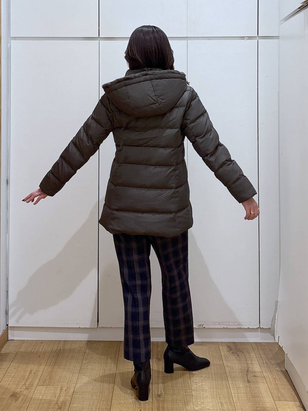 ブラウン系のダウンジャケット/コート、ブラック系のニット/セーター、ブルー系のその他パンツを着用したレディースの秋コーディネートの3枚目の写真