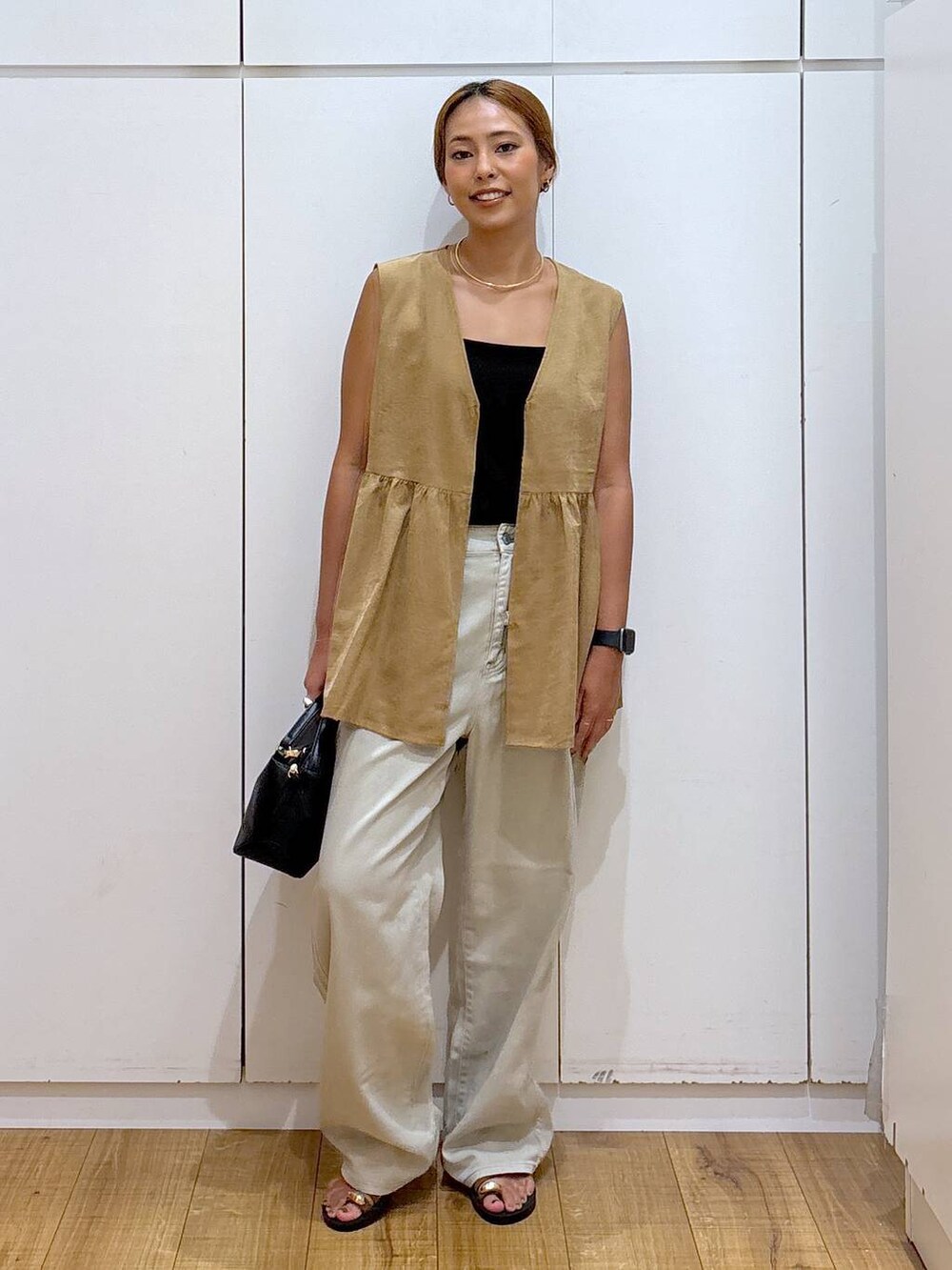 ブラック系のショルダーバッグ、ブラック系のキャミソール、ブラウン系のサンダルを着用したレディースの秋コーディネートの2枚目の写真