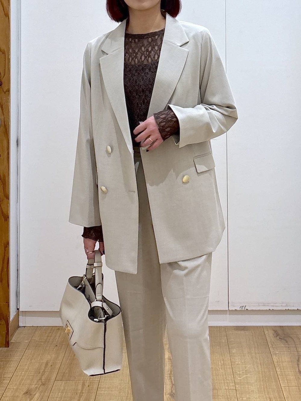 ベージュ系のスラックス、ベージュ系のテーラードジャケット、ベージュ系のショルダーバッグを着用したレディースの春コーディネートの5枚目の写真