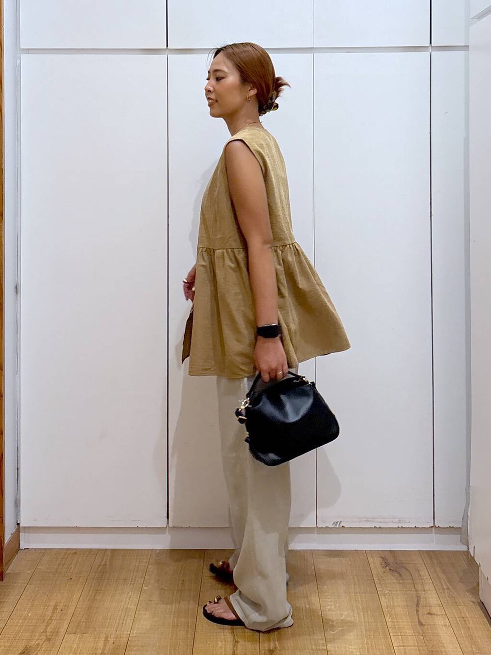 ブラック系のショルダーバッグ、ブラック系のキャミソール、ブラウン系のサンダルを着用したレディースの秋コーディネートの4枚目の写真