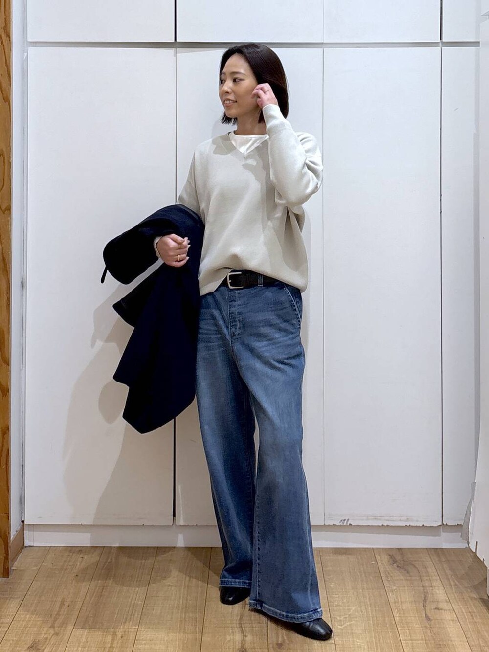 ブルー系のチェスターコート、ベージュ系のスウェット、ブラック系のブーツを着用したレディースの秋コーディネートの2枚目の写真