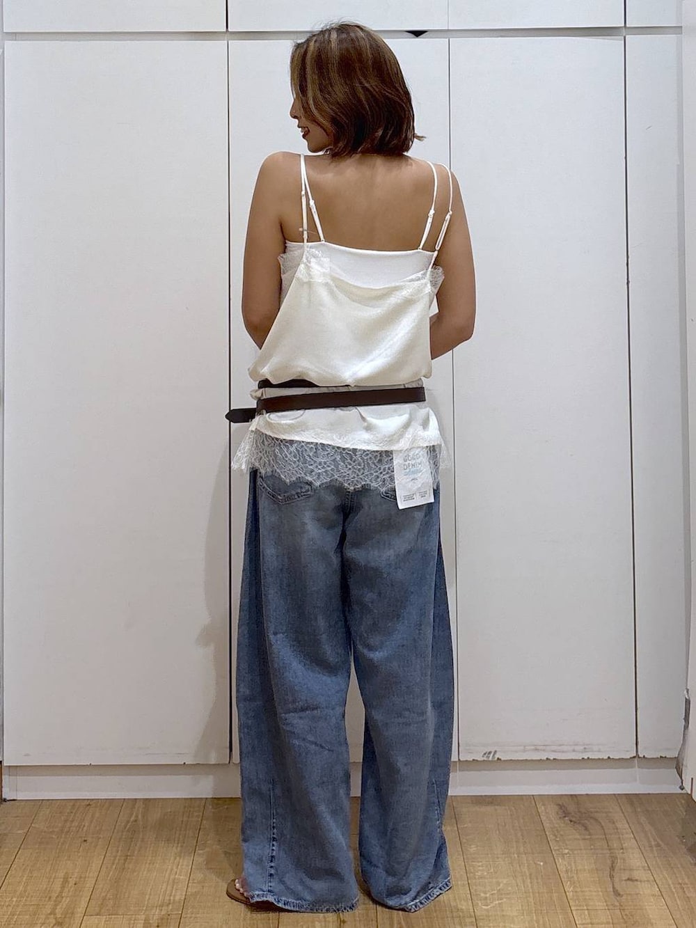 ホワイト系のキャミソール、ブルー系のデニムパンツ、ホワイト系のキャミソールを着用したレディースの春コーディネートの5枚目の写真