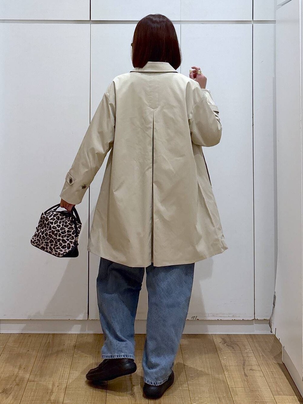 その他のショルダーバッグ、ブルー系のデニムパンツ、ベージュ系のステンカラーコートを着用したレディースの春コーディネートの4枚目の写真