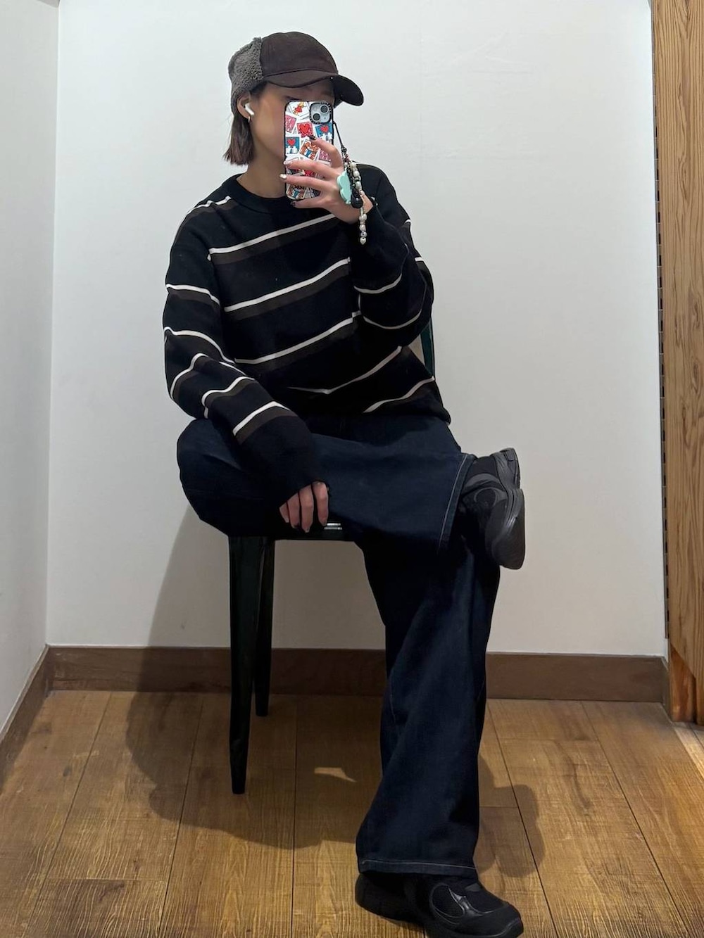 ブラック系のデニムパンツを着用したレディースの冬コーディネートの2枚目の写真