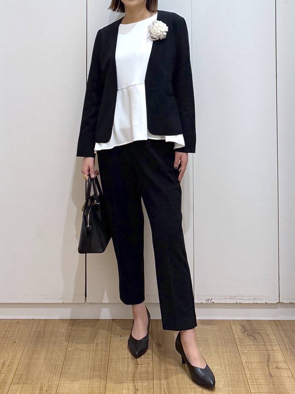 ブラック系のショルダーバッグ、ブラック系のパンプス、ブラック系のセットアップを着用したレディースの冬コーディネートの3枚目の写真