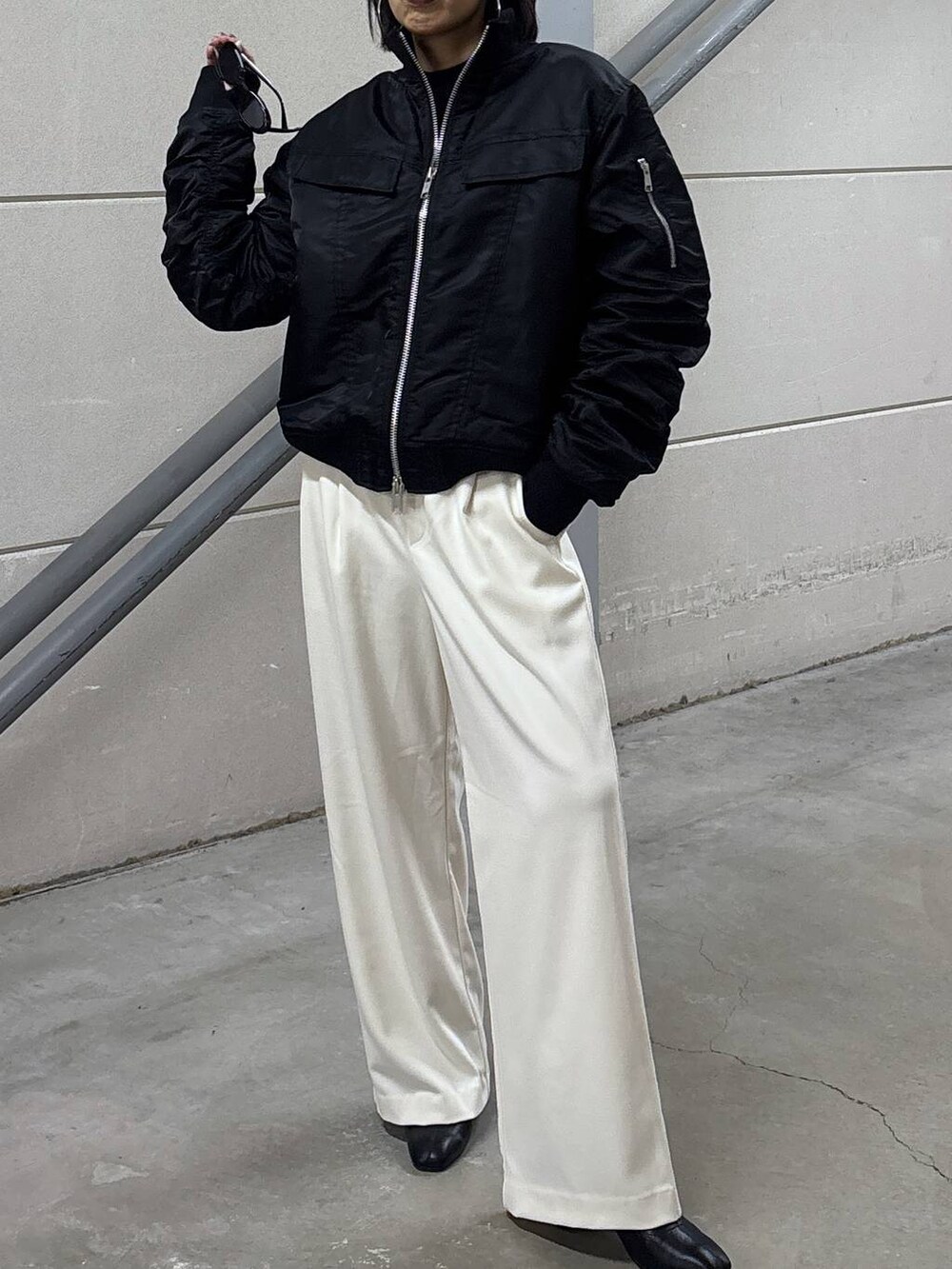 ブラック系のニット/セーター、グレー系のその他パンツ、ブラック系のブーツを着用したレディースの秋コーディネートの3枚目の写真