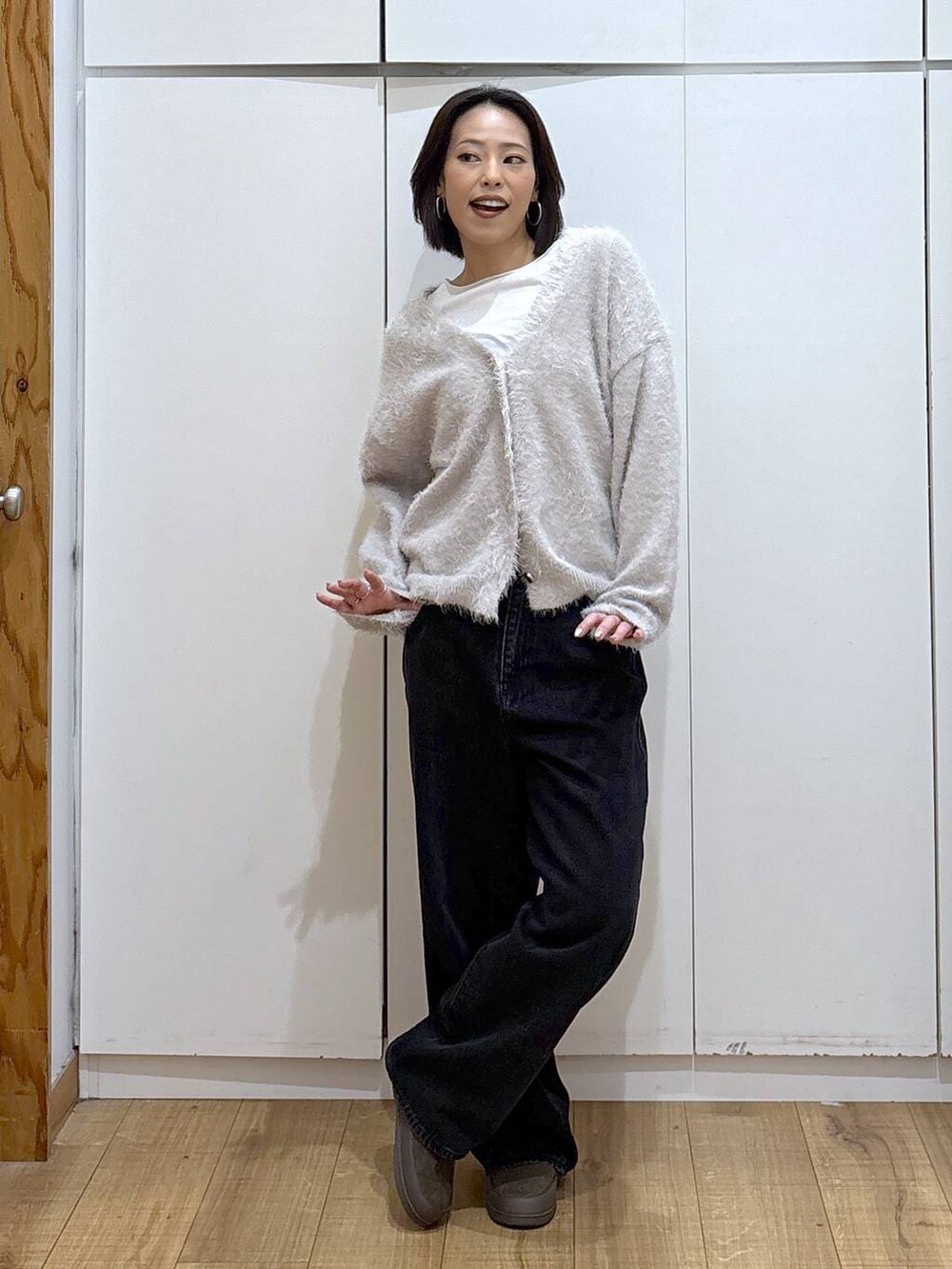 ブラック系のデニムパンツ、ベージュ系のカーディガン/ボレロ、グリーン系のその他シューズを着用したレディースの秋コーディネートの2枚目の写真