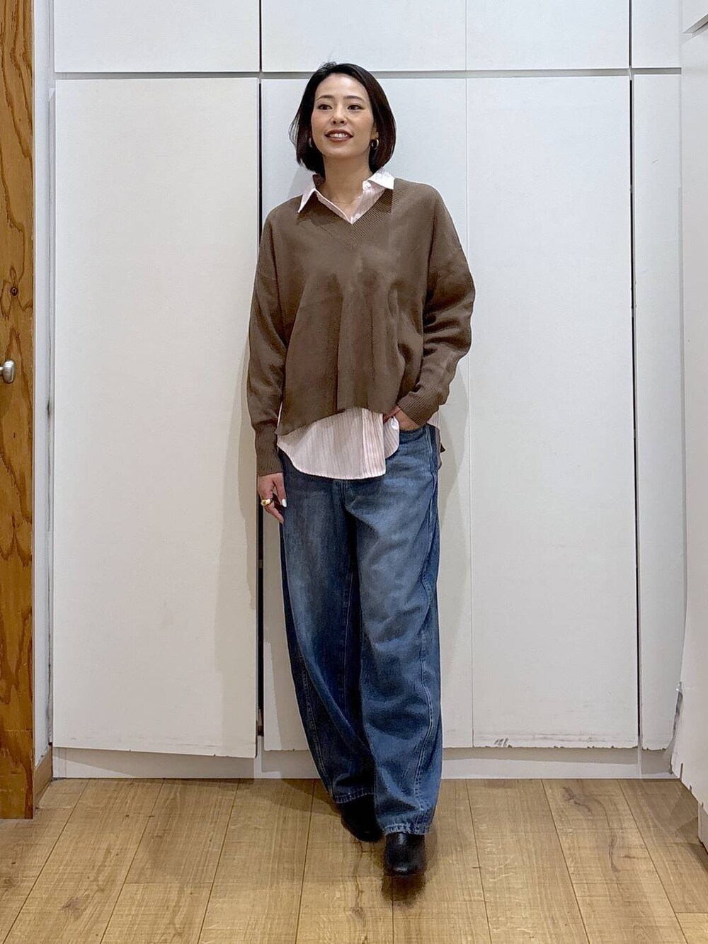 ピンク系のシャツ/ブラウス、ブラック系のブーツ、ブルー系のデニムパンツを着用したレディースの冬コーディネートの3枚目の写真