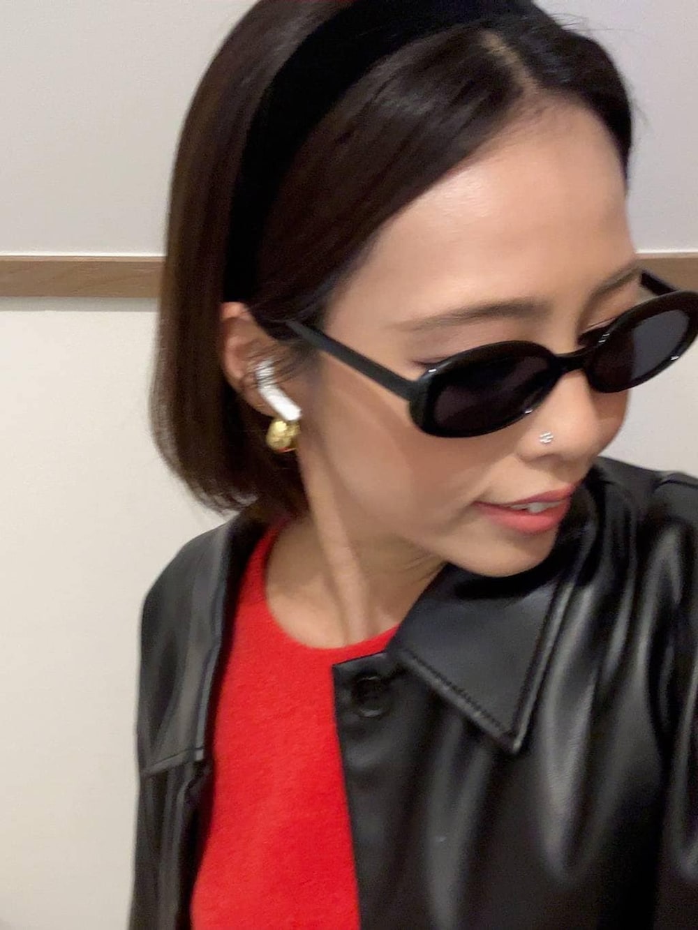 ブラック系のブルゾン、レッド系のニット/セーター、ブラック系のカチューシャを着用したレディースの秋コーディネートの5枚目の写真