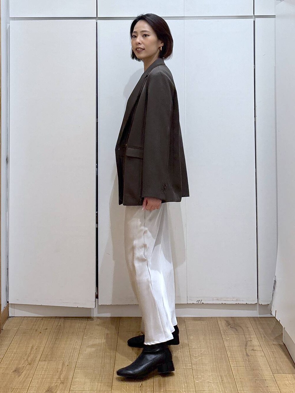 ブラック系のブーツ、ブラウン系のテーラードジャケット、グレー系のスカートを着用したレディースの冬コーディネートの5枚目の写真