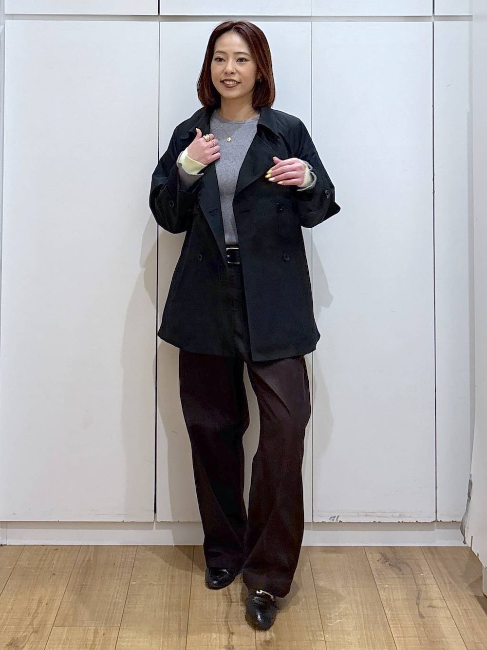 ブラック系のローファー、ブルー系のトレンチコート、グレー系のニット/セーターを着用したレディースの春コーディネートの7枚目の写真