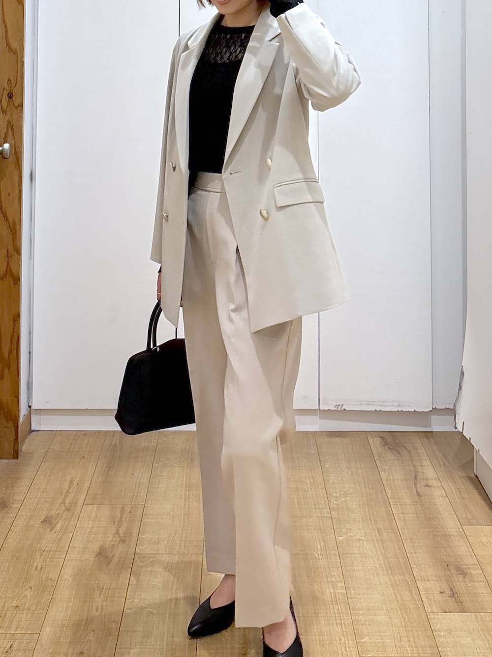 ブラック系のショルダーバッグ、ブラック系のパンプス、ブラック系のTシャツ/カットソーを着用したレディースの冬コーディネートの6枚目の写真