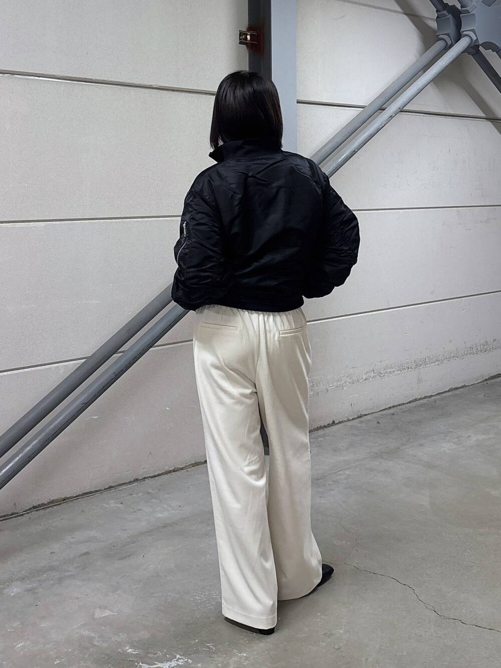 ブラック系のニット/セーター、グレー系のその他パンツ、ブラック系のブーツを着用したレディースの秋コーディネートの6枚目の写真