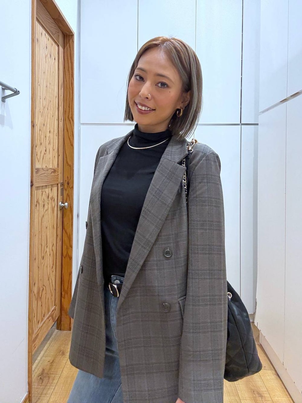 ブラック系のトートバッグ、ブラック系のTシャツ/カットソー、ブラック系のブーツを着用したレディースの秋コーディネートの3枚目の写真