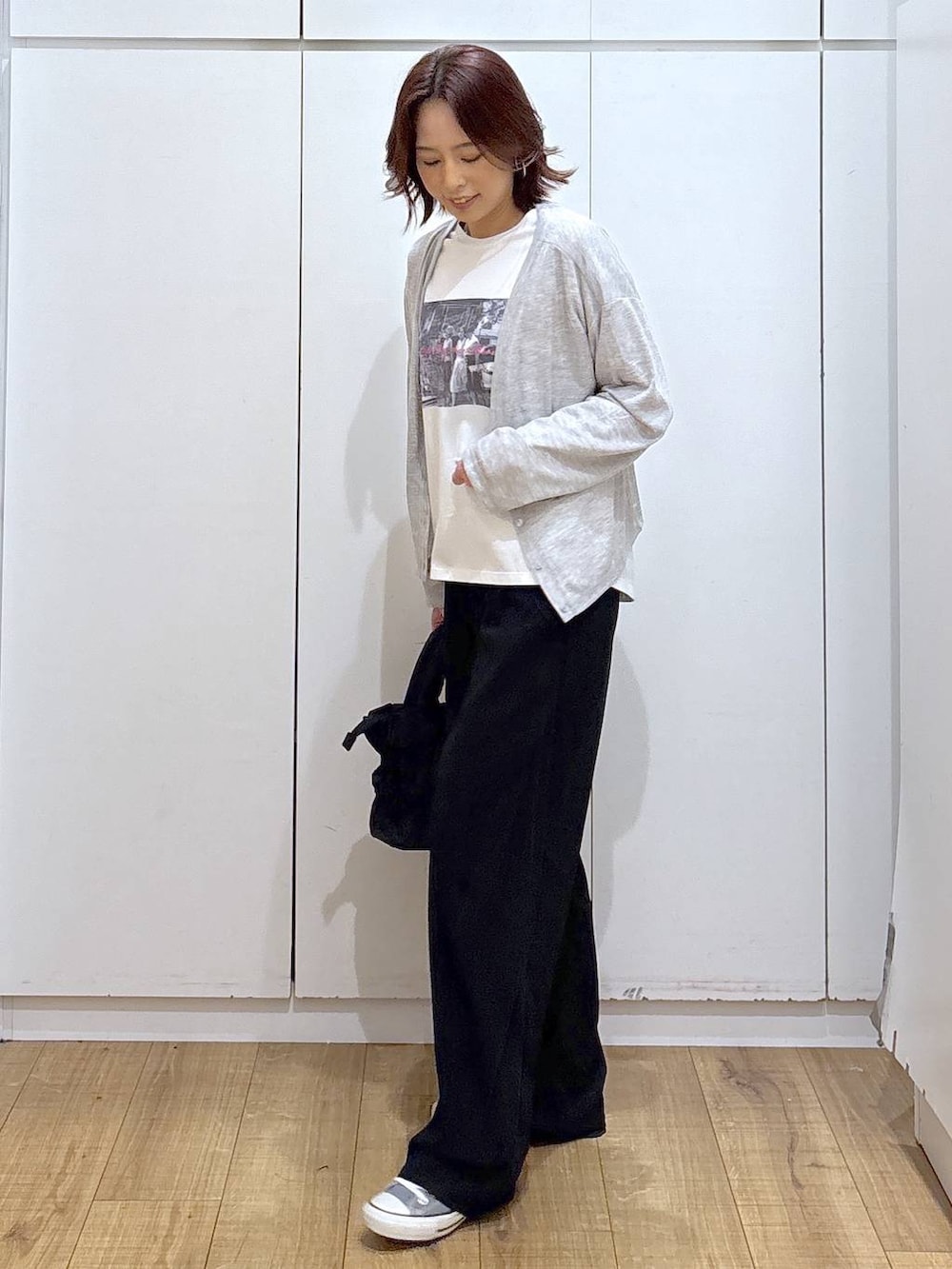 ブラック系のトートバッグ、ブラック系のその他パンツ、ホワイト系のTシャツ/カットソーを着用したレディースの春コーディネートの2枚目の写真