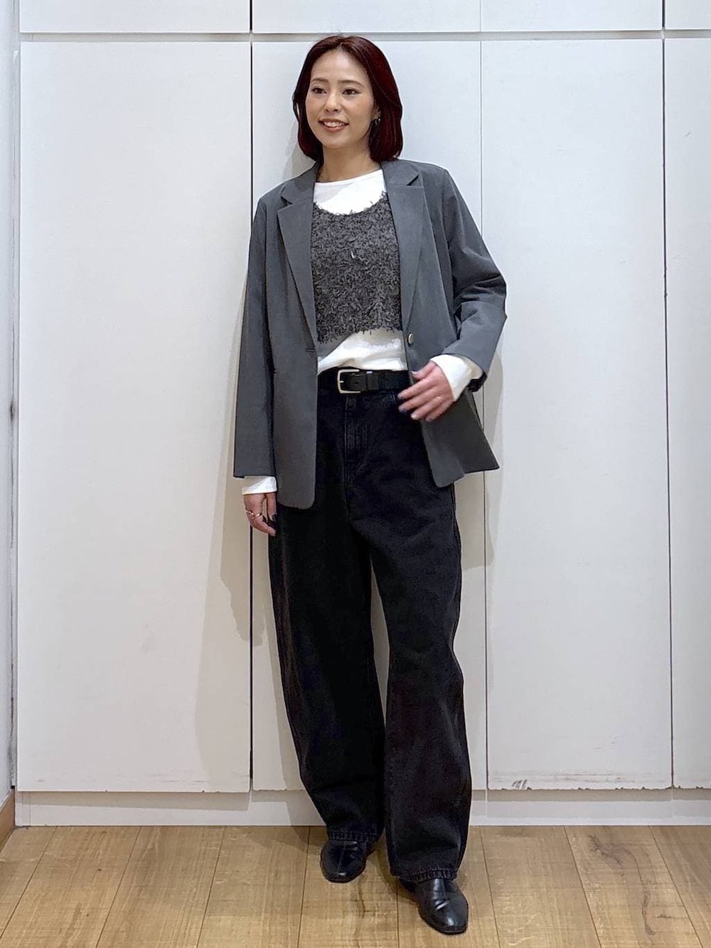 グレー系のテーラードジャケット、ブラック系のブーツ、ブラック系のデニムパンツを着用したレディースの春コーディネートの6枚目の写真