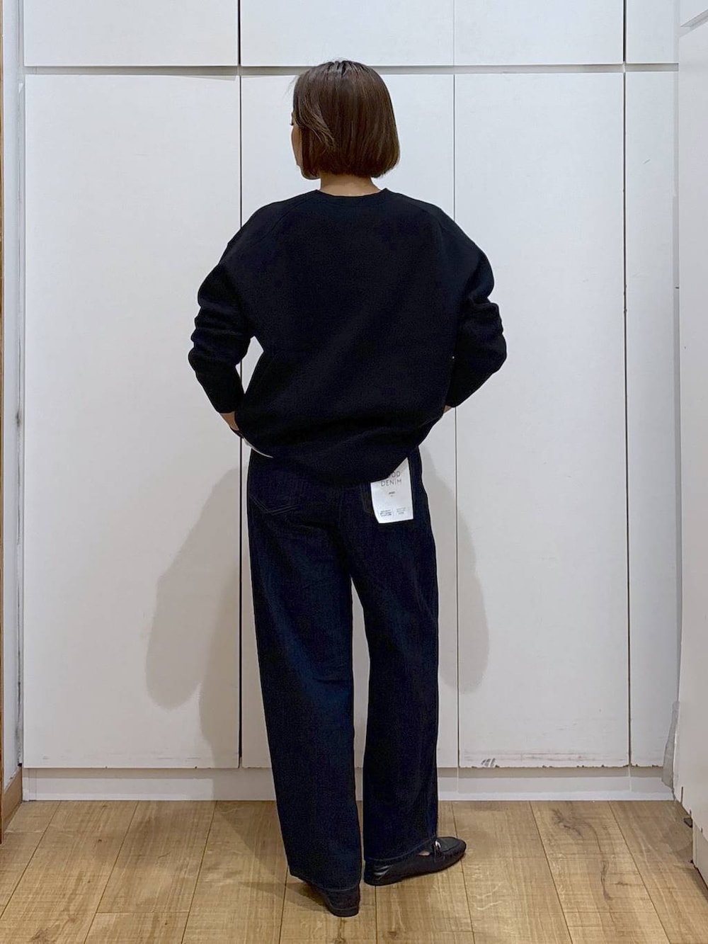 ブラック系のローファー、ブルー系のデニムパンツ、ブラック系のスウェットを着用したレディースの秋コーディネートの4枚目の写真