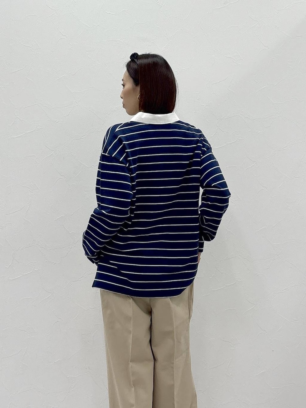 ブラック系のスニーカー、ベージュ系のチノパンツ、グリーン系のスウェットを着用したレディースの冬コーディネートの5枚目の写真