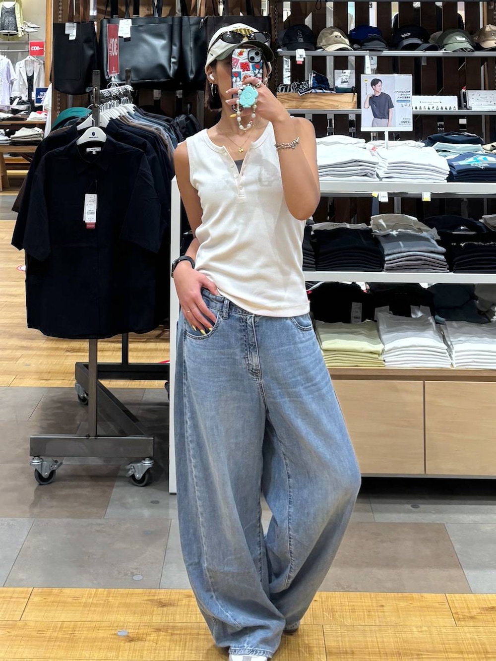ブルー系のデニムパンツ、ホワイト系のタンクトップを着用したレディースの夏コーディネートの2枚目の写真