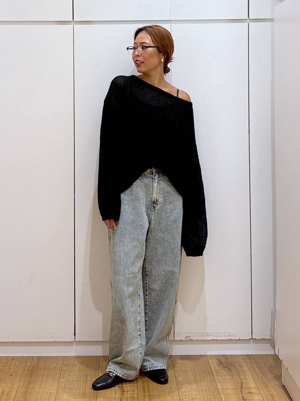 ブラック系のローファー、ブルー系のデニムパンツ、ブラック系のニット/セーターを着用したレディースの秋コーディネートの2枚目の写真