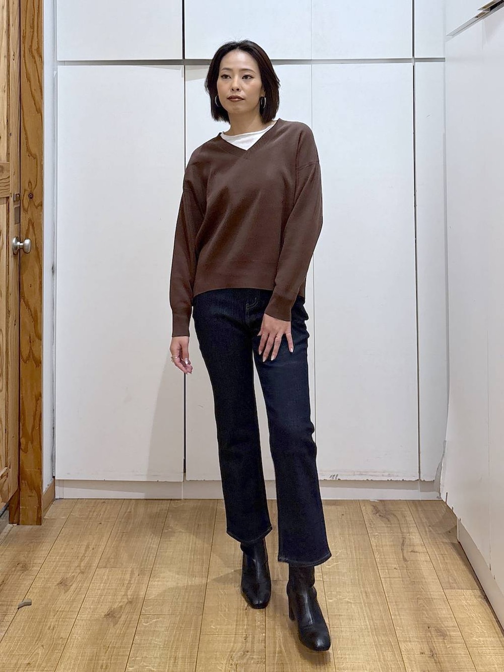 ブルー系のデニムパンツ、ブラウン系のスウェット、ブラック系のブーツを着用したレディースの秋コーディネートの5枚目の写真