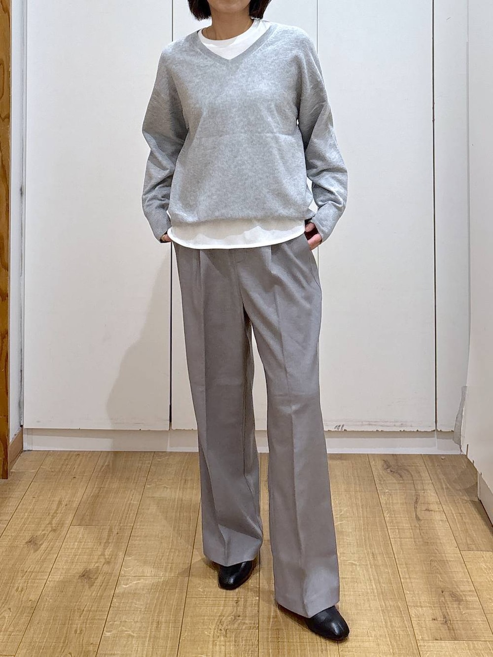 ブラウン系のチェスターコート、グレー系のその他パンツ、ホワイト系のTシャツ/カットソーを着用したレディースの秋コーディネートの5枚目の写真