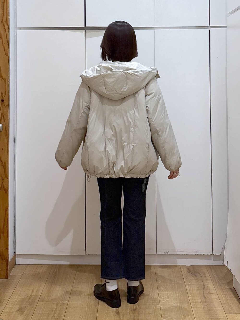 ベージュ系のダウンジャケット/コート、ブルー系のデニムパンツ、ブルー系のニット/セーターを着用したレディースの秋コーディネートの4枚目の写真