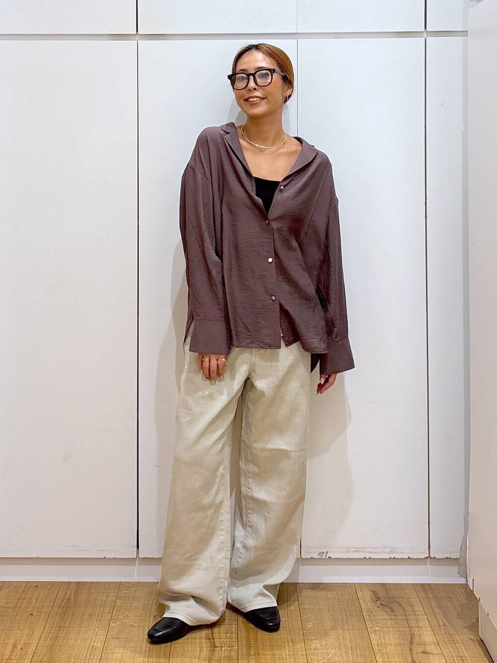 ブラック系のローファー、ブラック系のキャミソール、ベージュ系のデニムパンツを着用したレディースの秋コーディネートの4枚目の写真