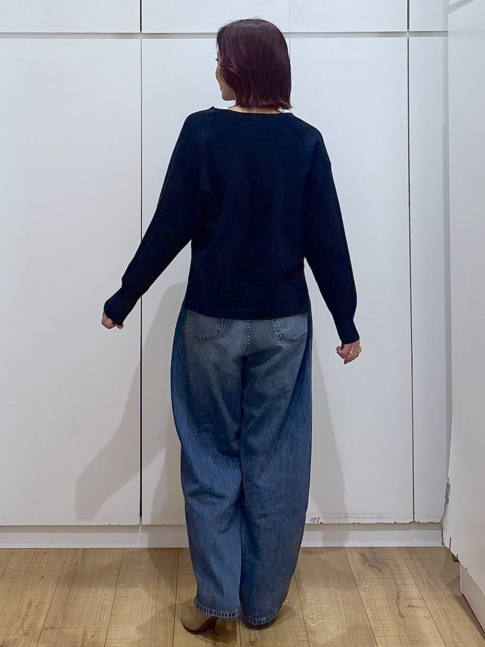 ブルー系のデニムパンツ、ブルー系のニット/セーター、ゴールド系のリングを着用したレディースの春コーディネートの4枚目の写真