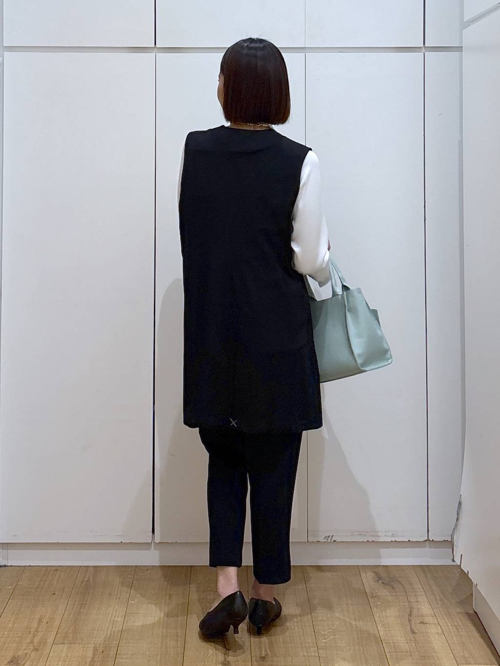 ブラック系のパンプス、ブラック系のスラックス、ブラック系のセットアップを着用したレディースの冬コーディネートの7枚目の写真