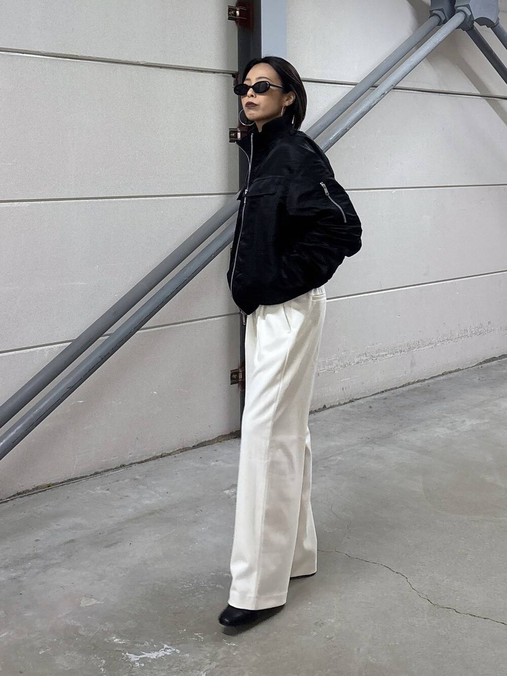 ブラック系のニット/セーター、グレー系のその他パンツ、ブラック系のブーツを着用したレディースの秋コーディネートの4枚目の写真