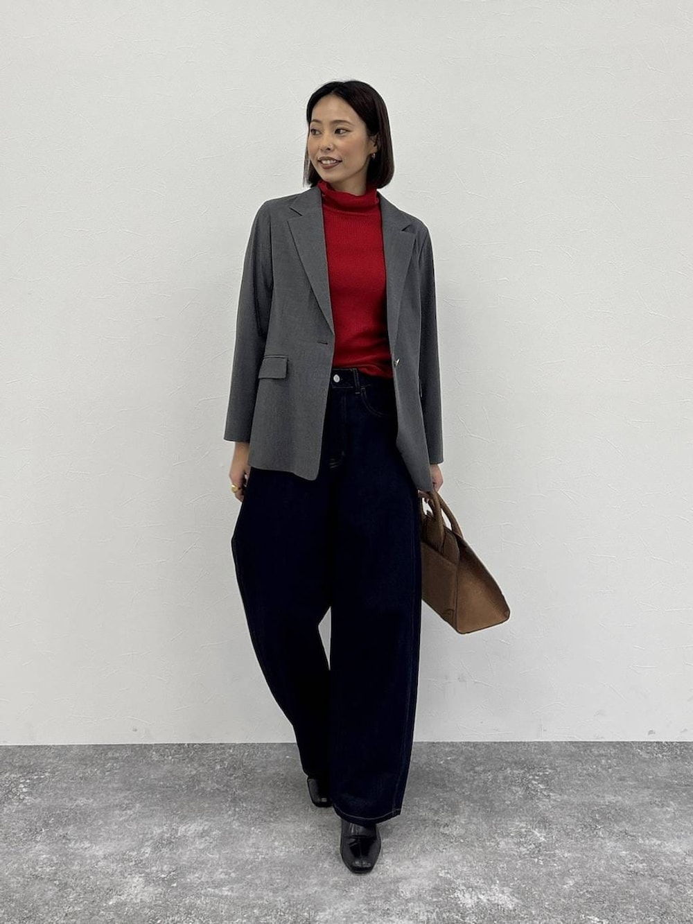 ブラウン系のトートバッグ、グレー系のテーラードジャケット、ブラック系のブーツを着用したレディースの冬コーディネートの2枚目の写真