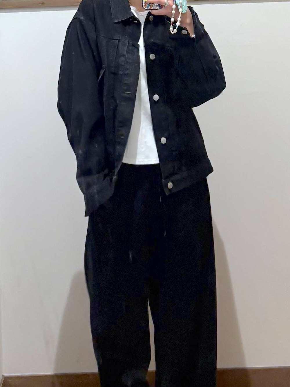 ブラック系のデニムジャケット、ブラック系のスウェットパンツ、ゴールド系のネックレスを着用したレディースの春コーディネートの4枚目の写真