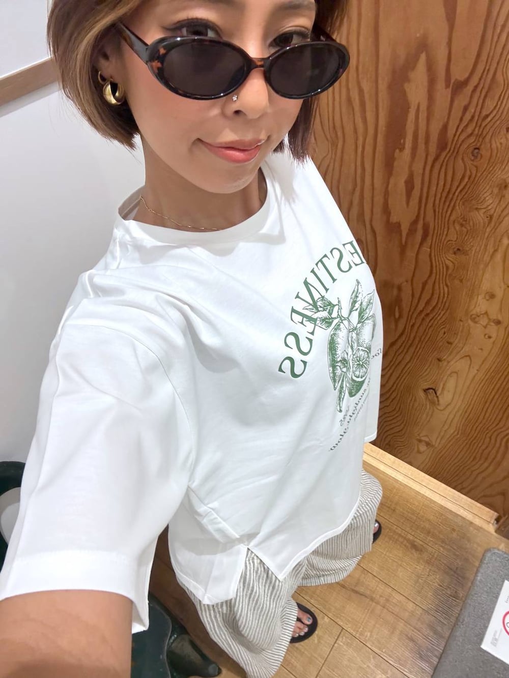 ホワイト系のTシャツ/カットソー、ホワイト系のその他パンツ、ブラック系のサンダルを着用したレディースの夏コーディネートの7枚目の写真