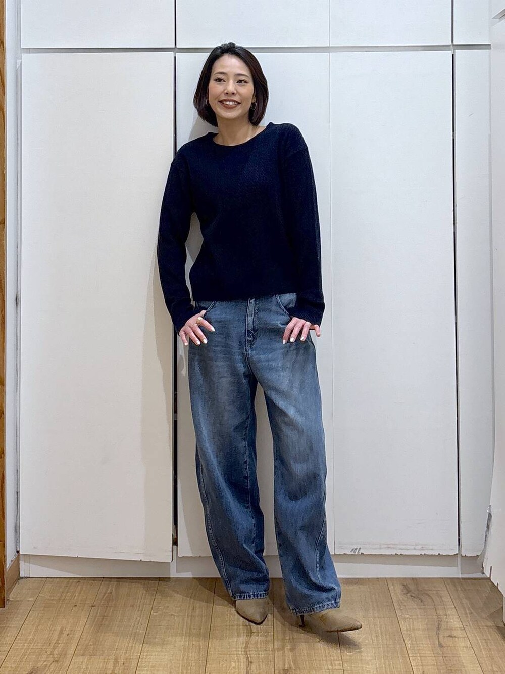 ブルー系のニット/セーター、ベージュ系のブーツ、ブルー系のデニムパンツを着用したレディースの冬コーディネートの5枚目の写真