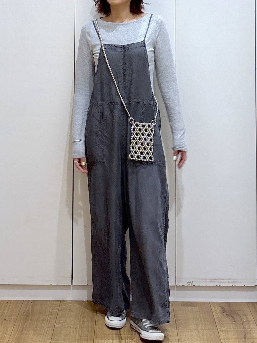 ブラック系のサロペット/オーバーオール、グレー系のスマホグッズを着用したレディースの春コーディネートの2枚目の写真