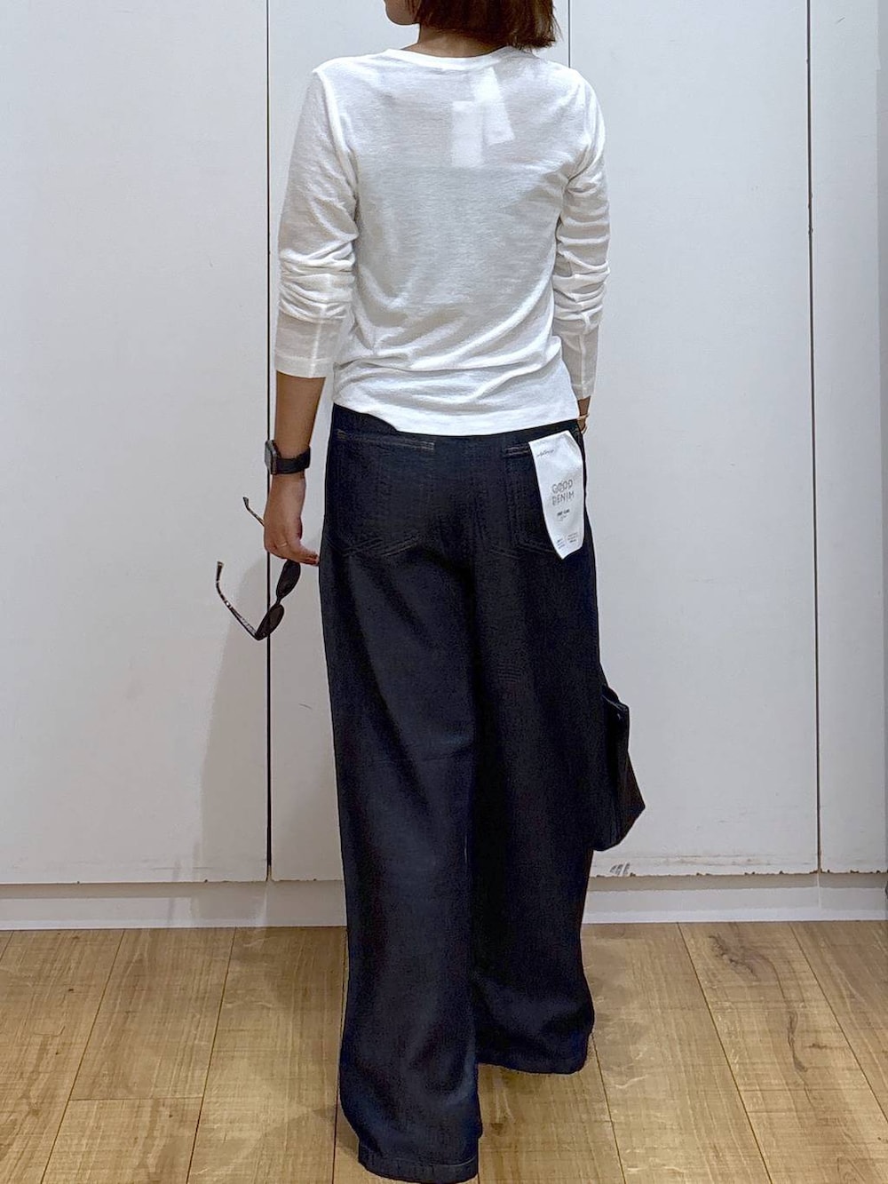 ホワイト系のTシャツ/カットソー、ブラック系のハンドバッグ、ブラック系のキャミソールを着用したレディースの夏コーディネートの5枚目の写真