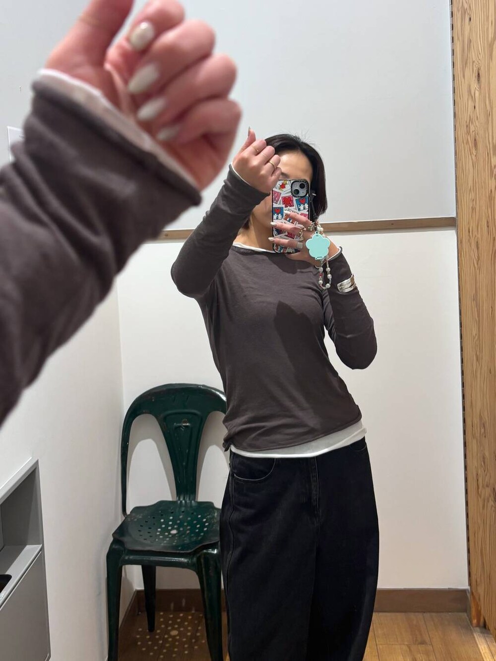 ブラック系のデニムパンツ、ブラック系のスニーカー、ホワイト系のTシャツ/カットソーを着用したレディースの秋コーディネートの3枚目の写真