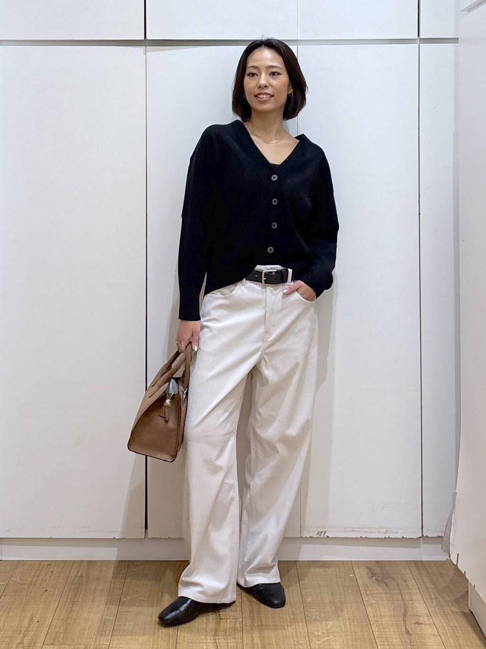 ブラック系のカーディガン/ボレロ、グレー系のその他パンツ、ベージュ系のショルダーバッグを着用したレディースの秋コーディネートの3枚目の写真