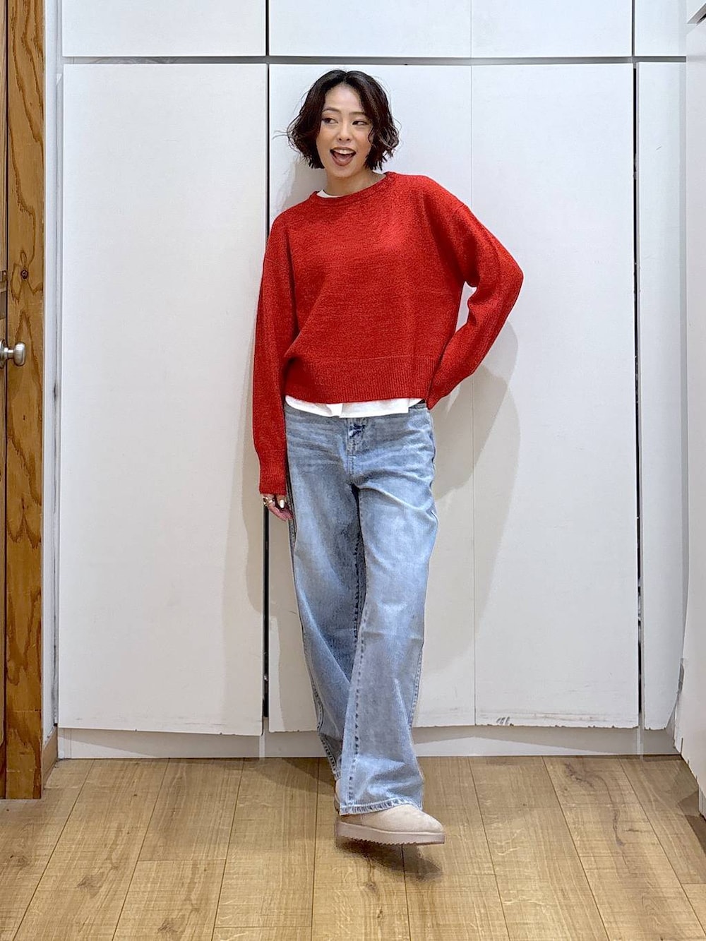 ブルー系のデニムパンツ、レッド系のニット/セーター、ホワイト系のTシャツ/カットソーを着用したレディースの冬コーディネートの4枚目の写真