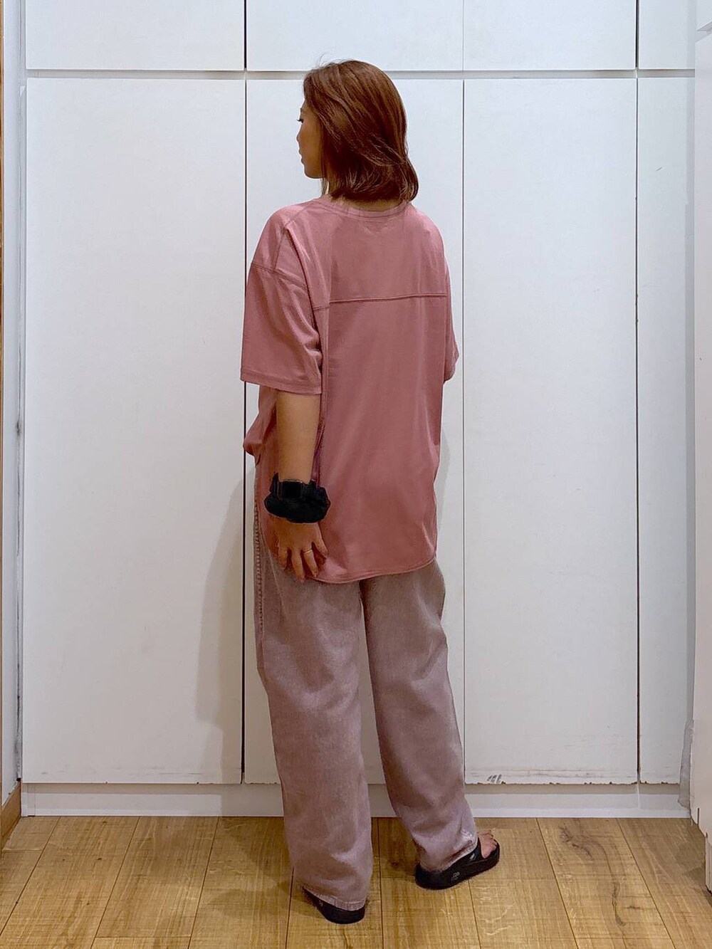ピンク系のデニムパンツ、ピンク系のTシャツ/カットソー、ブラック系のサンダルを着用したレディースの夏コーディネートの4枚目の写真
